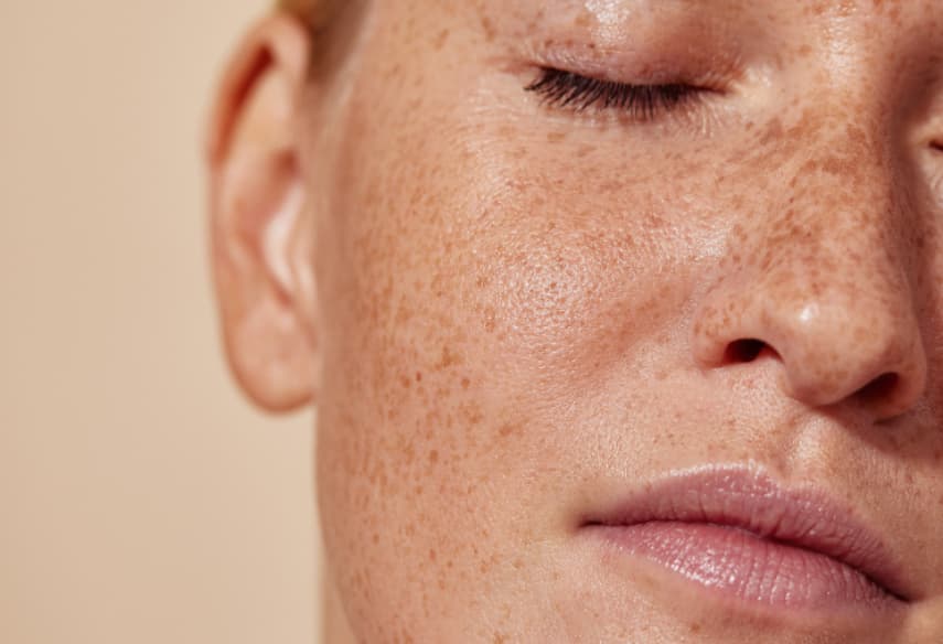 Woman gently patting her face dry with a biodegradable disposable face towel